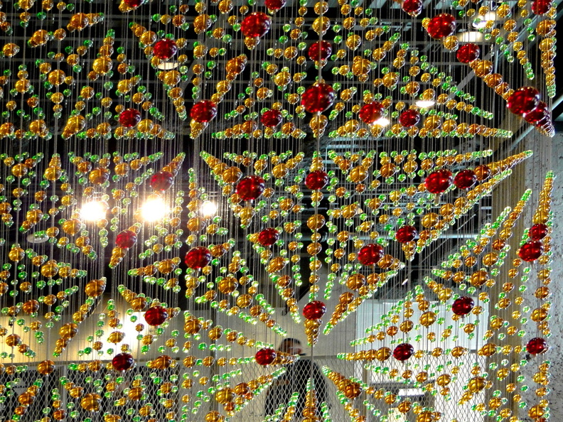 The image showcases a vibrant display of Christmas decorations, featuring an array of colorful ornaments, lights and festive designs. The background is dimly lit, which helps to highlight the intricate details and bright colors of the decorations. This could be an indoor setting, possibly in a shopping mall or a holiday-themed event space. DSC09087.JPG