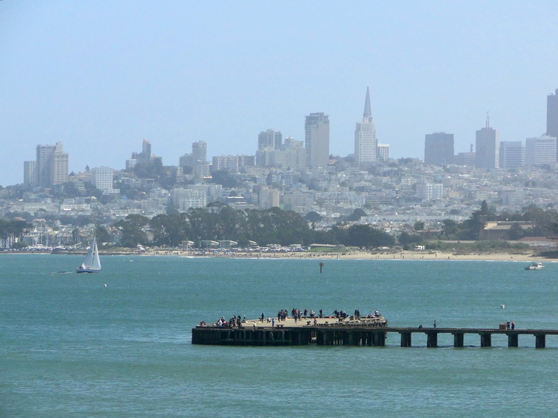 Photograph capturing a vibrant waterfront scene featuring the iconic skyline of San Francisco, California. The image showcases a pier extending into the bay, dotted with people enjoying the view and clear skies. DSC09277.JPG