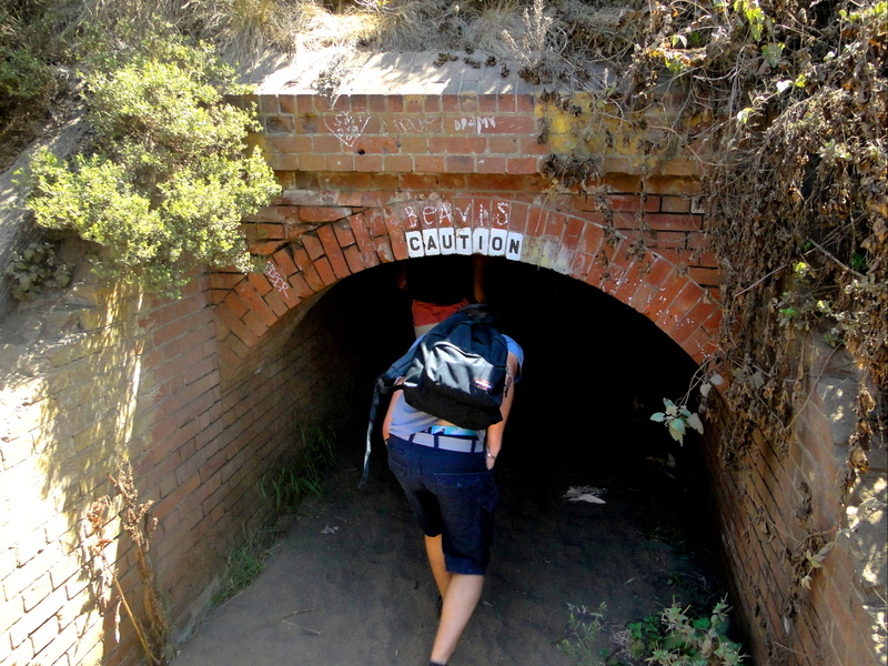 A Hiker at the Entrance of an Abandoned Tunnel