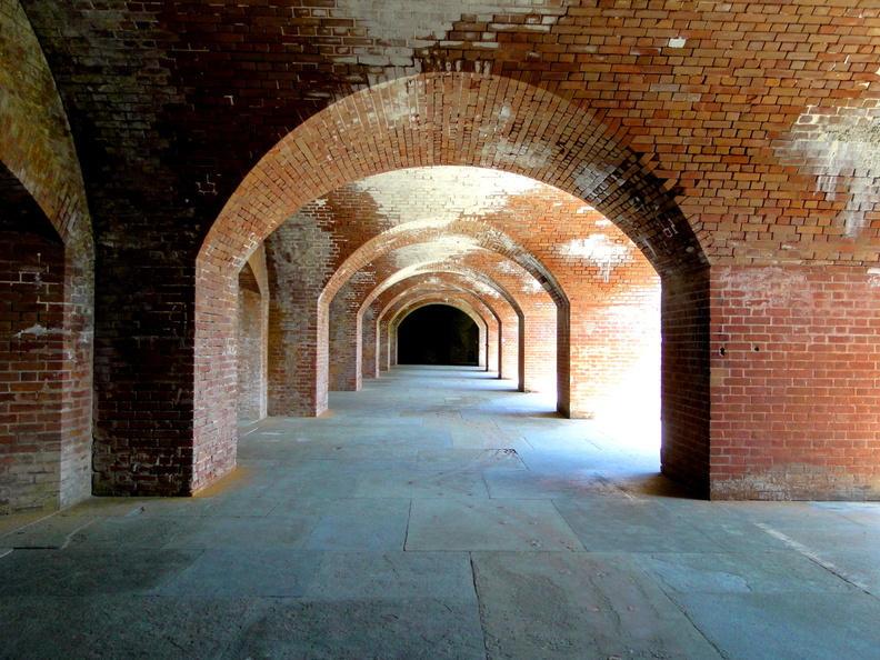 This image captures the haunting beauty of an abandoned brick archway within a building located in San Francisco. The red brick walls, arches, and floors create a striking contrast against the empty room. The structure's grandeur is evident despite its state of disrepair, hinting at a bygone era when it was likely filled with bustling activity. The perspective of the image invites the viewer to imagine the space once again teeming with life. DSC09244.JPG