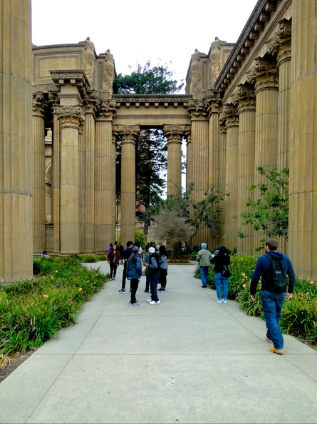 This image captures the grandeur of the historic San Francisco City Hall. The courtyard is bustling with visitors who are exploring and appreciating this architectural marvel. In the foreground, a stone pathway leads to the main entrance, flanked by large columns that add to the classical aesthetic. The city's vibrant greenery in the background enhances the urban setting. This location serves as a gathering place for tourists and locals alike, offering a glimpse into the city's rich history. DSC09845.JPG