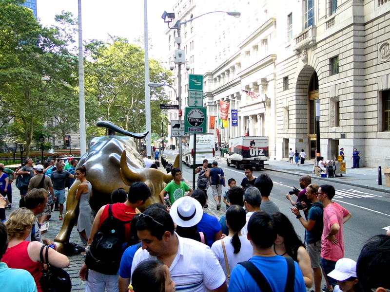 Crowd Gathered around a Bull Sculpture in New York