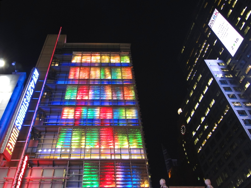 Vibrant Cityscape at Night with Multi-Colored Light Projection