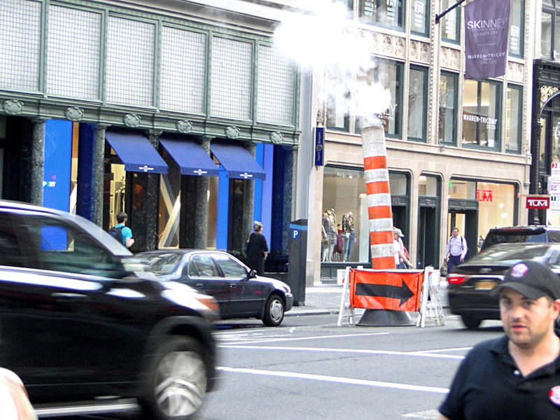 Bustling City Street with Steam Emanating from Road Construction