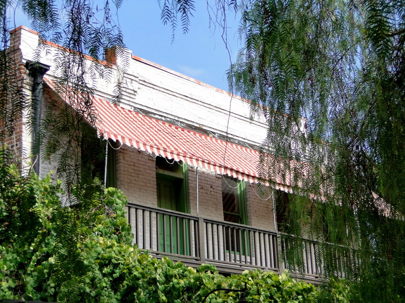 A quaint two-story house with a red tile roof, located in Los Angeles.