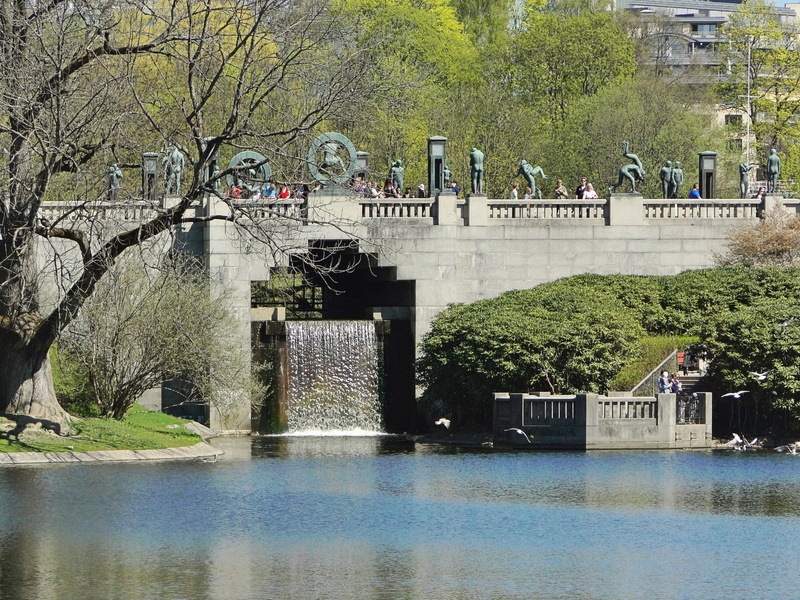 Urban Oasis: A Springtime Riverbank Scene with a Bridge