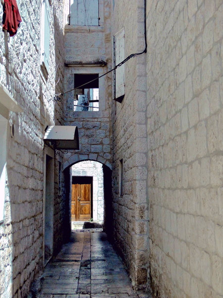 Trogir's Narrow Stone Alleyway in Croatia, bathed in sunlight