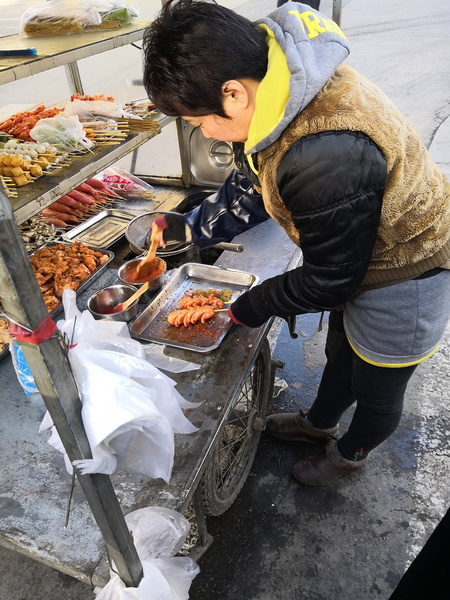 Vendor Preparing Food at a Street Market Stall