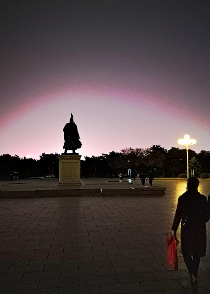 A Tranquil Night in Shenyang, China - A Silhouette Walks Past a Majestic Statue