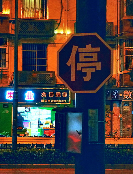 Vibrant Chinese Night Street with a Stop Sign in Hangzhou