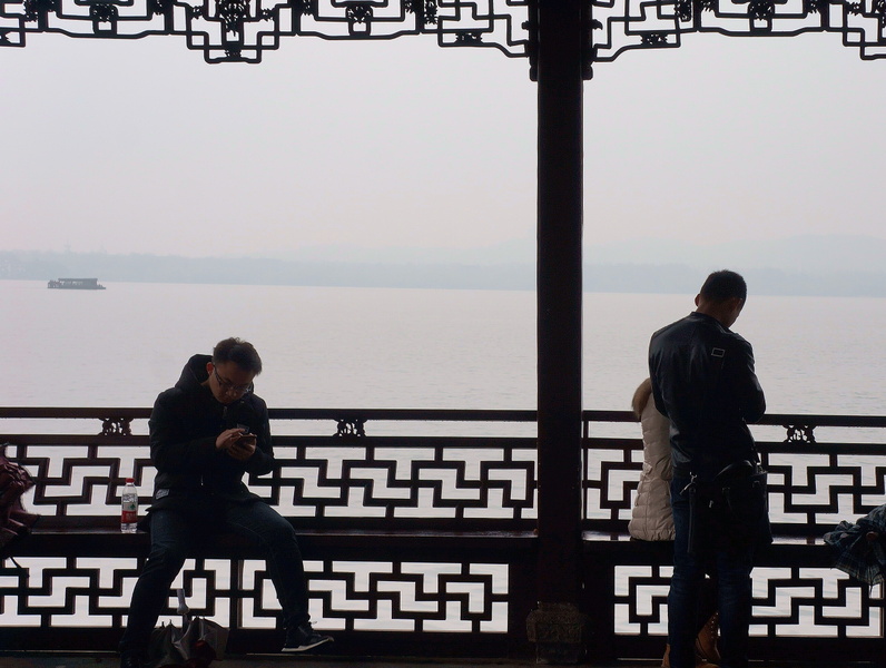 Two People on a Bench at a Chinese Lakefront with Foggy Background