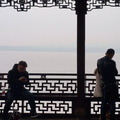 Two People on a Bench at a Chinese Lakefront with Foggy Background