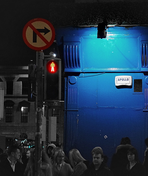 An atmospheric nighttime shot captures the vibrant energy of a bustling Dublin street corner. The iconic blue door stands out, illuminated by a red arrow sign that reads 'Philip'. Its prominent location on the corner suggests it might be the entrance to a popular pub or venue named Philip's. DSC07108.JPG