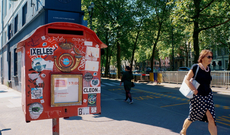 A lively street corner in Brussels, Belgium showcasing a red mailbox and a city bus stop. DSC07968.JPG