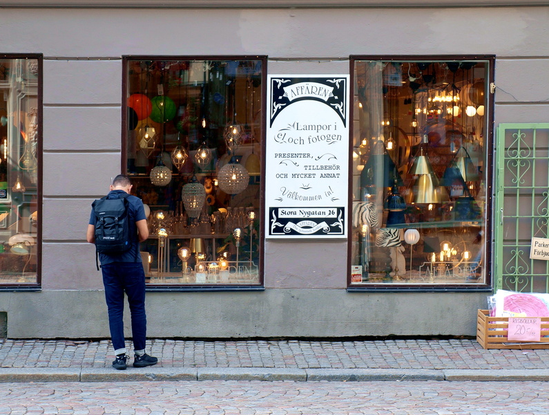 A Tourist Explores a Shop Window in Stockholm