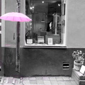 Stockholm Chic: A Pink Umbrella Enhances a Modern Storefront on a Rainy Day