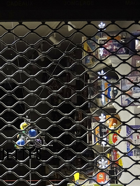 Nighttime View of a Store's Exterior Through a Wire Fence