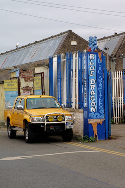 A quaint town scene featuring a pub and parked truck