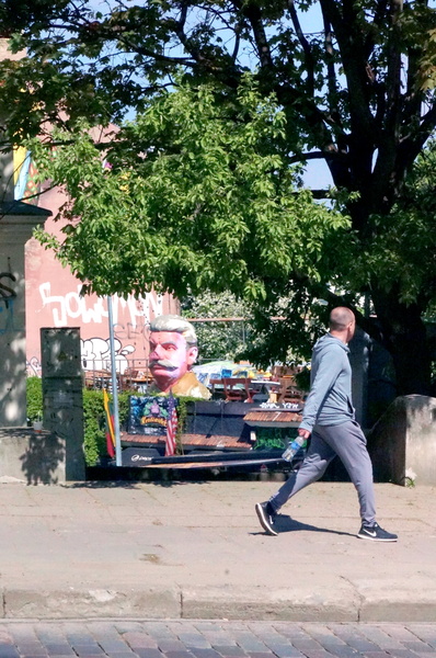 An Individual Walks Past a Grafiti Mural in Vilnius, Lithuania