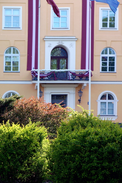 Yellow Building with Red and White Stripes and Flag