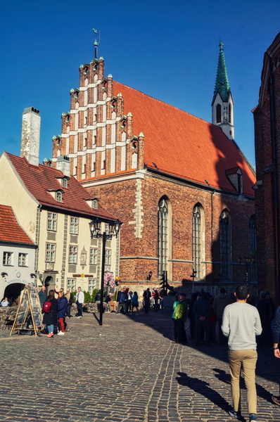 Riga's Historic Old Town with a Towering Gothic Church and Strolling Tourists
