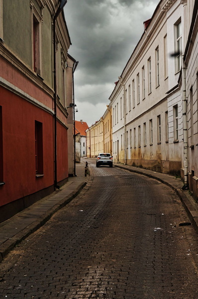 Narrow Alleyway in a European City under Cloudy Skies