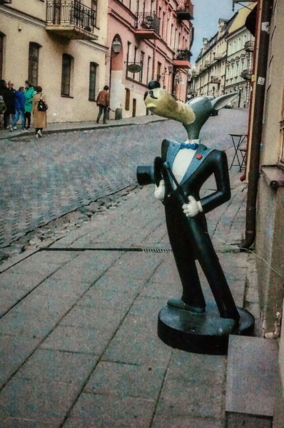 A whimsical street scene in Vilnius, featuring a statue of Edgar Allan Poe