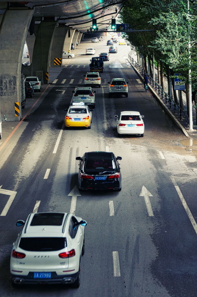An overhead image capturing the bustling traffic of a major road in Shenyang, China. The scene showcases a variety of vehicles including cars and buses navigating through the city's underground tunnel. This perspective provides a unique view of the city's transportation infrastructure during peak hours. DSC00936.jpg