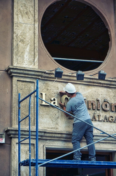 Construction Worker Repairing Signage