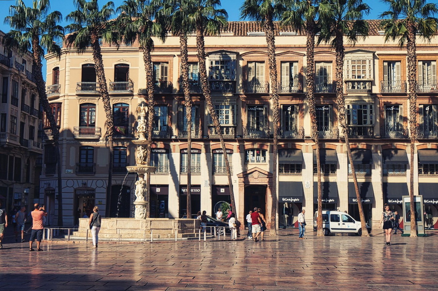 Malaga, Spain: City Square with Palm Trees and Pedestrians