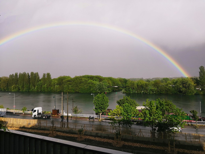 Rainbow Arching over a River and Surroundings