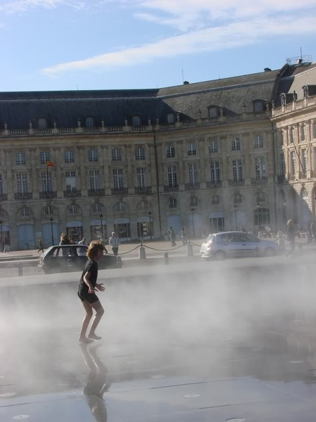 A child's joy at a water fountain in Bordeaux, France.