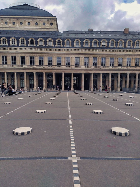 A Historic French Courtyard with Circular Patterns on Ground Level