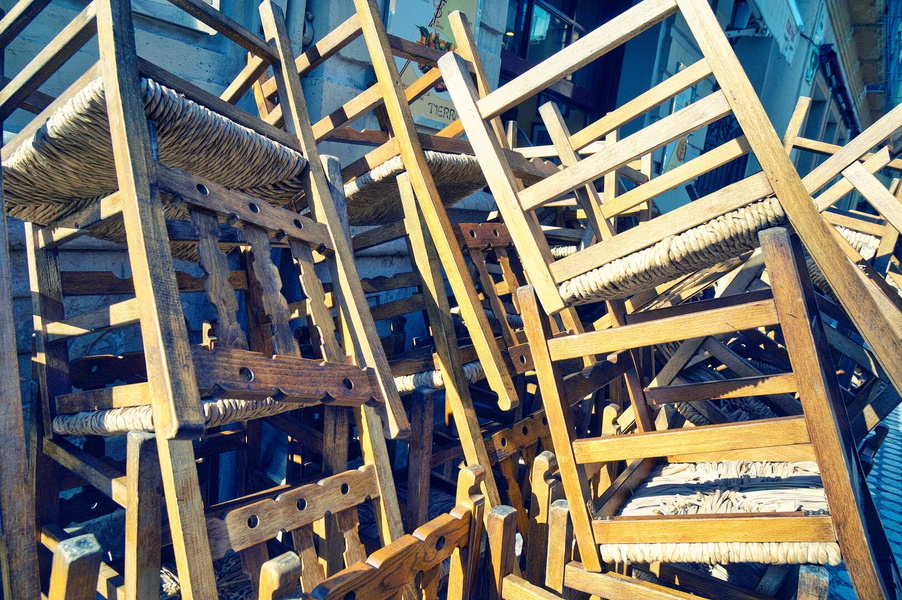 A pile of abandoned wooden chairs and benches