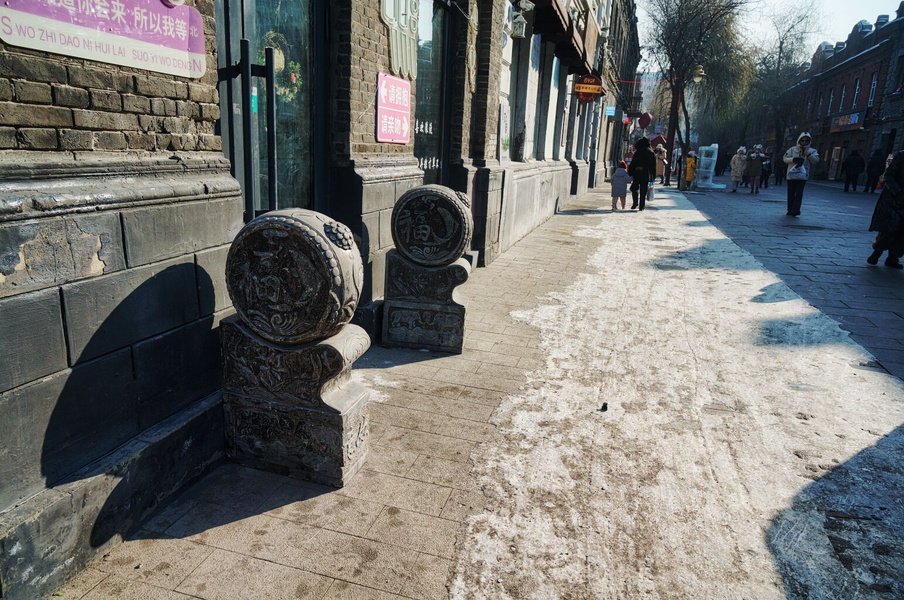 Scenic View of a Harbin, China Street with Decorative Stones and Storefronts