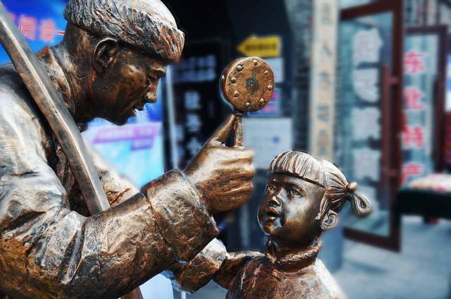 Interactive Public Art in China: A Statue of a Man and Child Encouraging Interaction