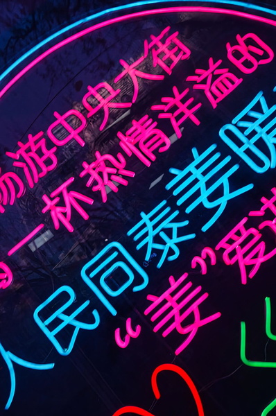 Colorful Neon Sign with Chinese Writing in a City Environment