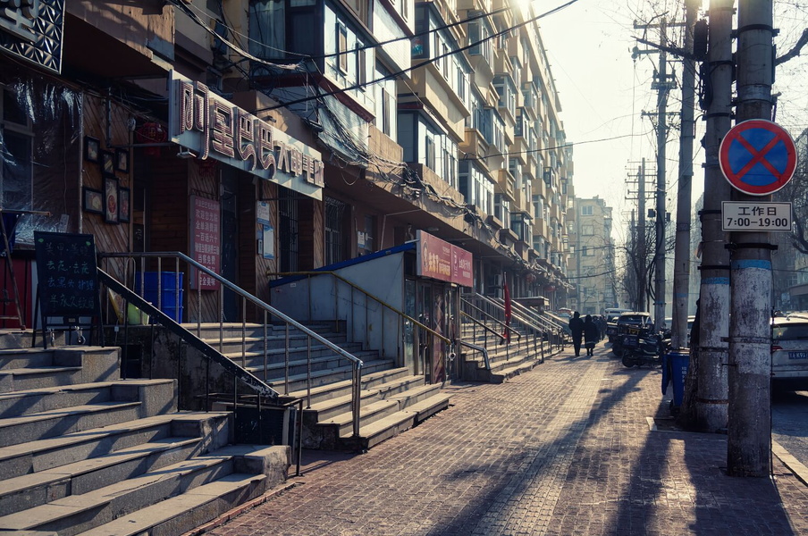 Harbin, China: A Sunlit Street with Commercial Buildings and Stairways