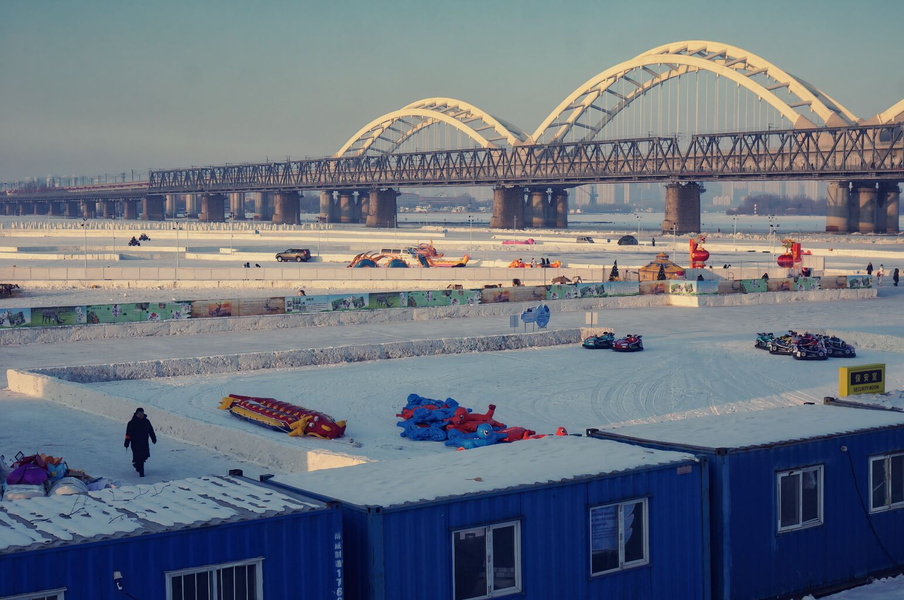 Winter Scene on Frozen River with Construction and Recreational Activities