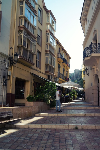 A Sunny Day in Malaga, Spain: Narrow Alley Leading to a Historic Building