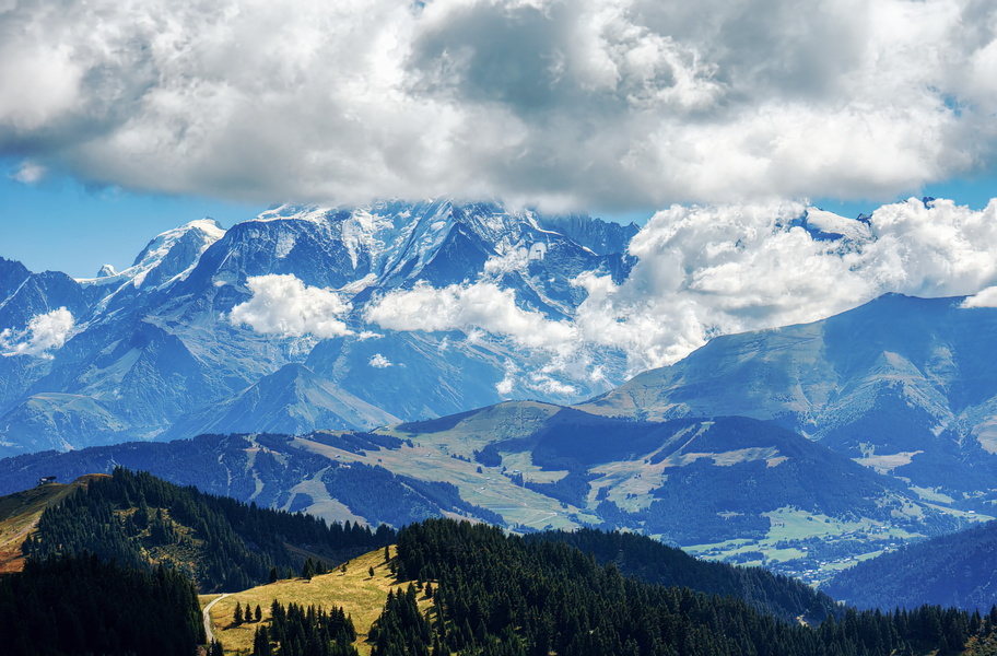 Serene Alpine Village with Majestic Mountains and Clouds Overlooking