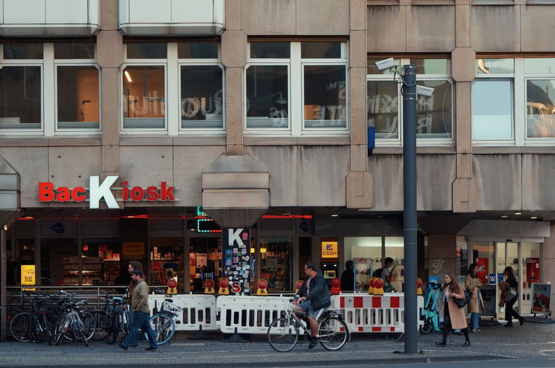 A Lively European Street Scene with Pedestrian Traffic and a Restaurant Sign