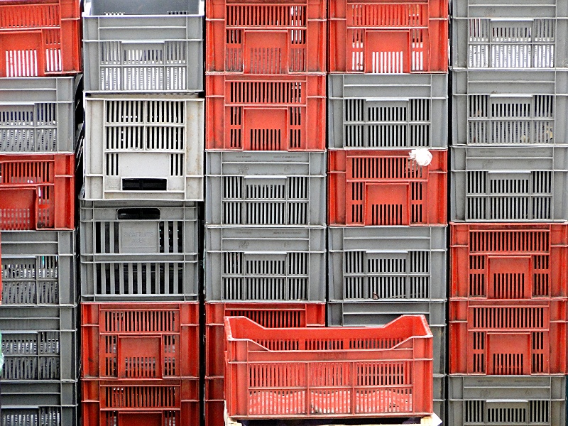 Stacked Cages of Various Sizes and Colors in a Rustic Setting